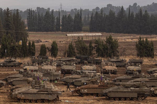 Rows of beige Israeli tanks with trees in the background. 