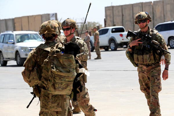 Three men in full military gear, including helmets and sunglasses. At least two are holding rifles.