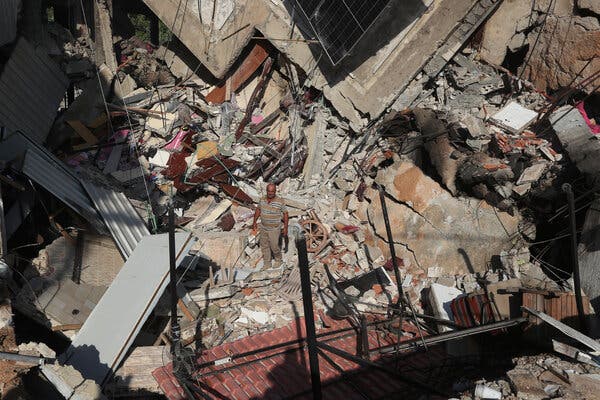 A man is barely visible amid a large pile of rubble.