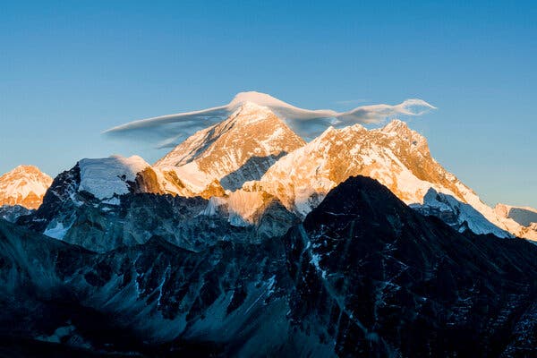 Mount Everest and other Himalayan peaks with a small cloud sitting at the top.