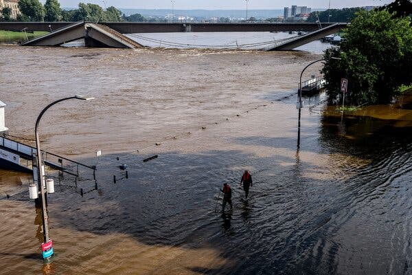 Floodwaters reach to the undersides of bridges, one of which has collapsed. 