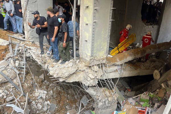 People standing amid debris and rubble caused by a missile strike. 