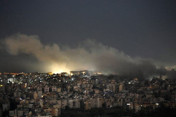 A city at night, illuminated by an explosion.