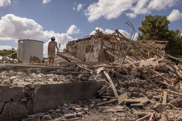 A person standing amid the ruins of a destroyed building.