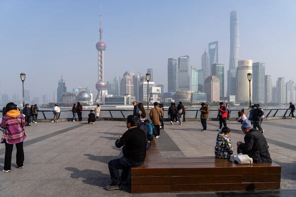 People at a waterside park with the Shanghai's financial district's skyline in the background.