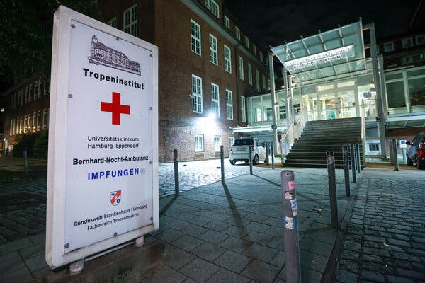 A sign board with a red cross marks the entrance to a medical building in Hamburg, Germany.