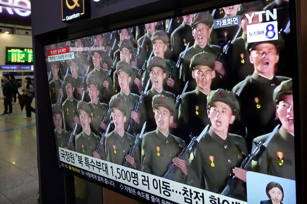 A television screen showing images of soldiers in green uniforms holding weapons.