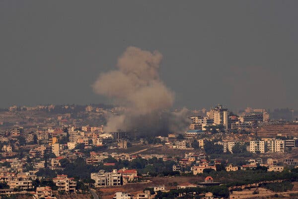 Smoke rising above buildings.