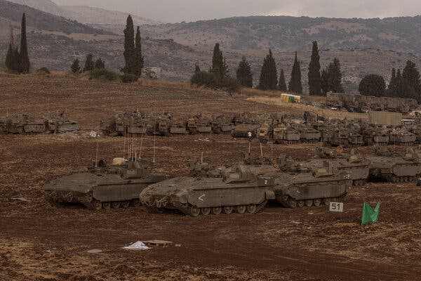 Military vehicles across a hilly area.