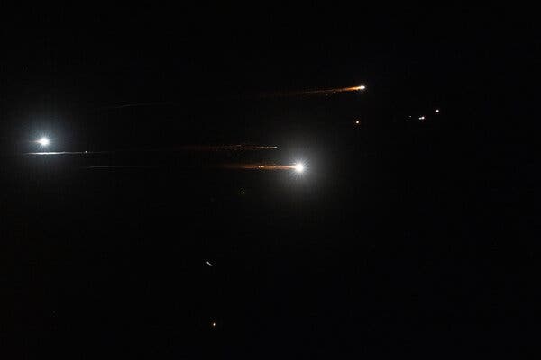 Missiles flaring in a night sky.