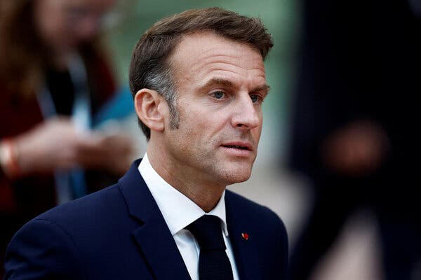 Emmanuel Macron is wearing a blue blazer and tie.