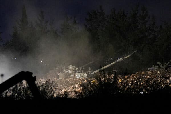 An artillery unit at night in a barren spot. 