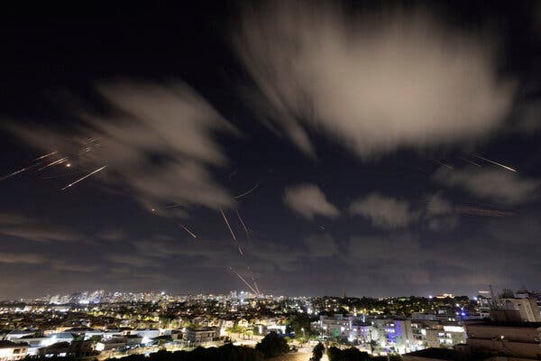 Missile defenses streak across a night sky.