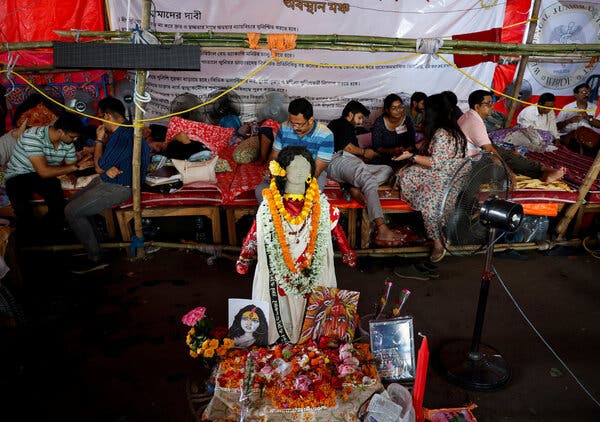 People sitting on makeshift benches set up behind a female idol.