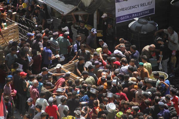 Crowds of people receiving food outside. 