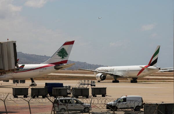 Two planes sit on the tarmac of an airport.