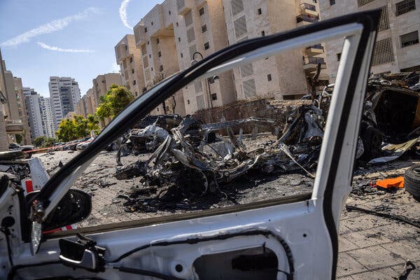 Badly burned and damaged cars in the parking lot of an apartment complex. 