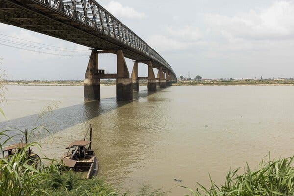 A broad, muddy river with a bridge running across.