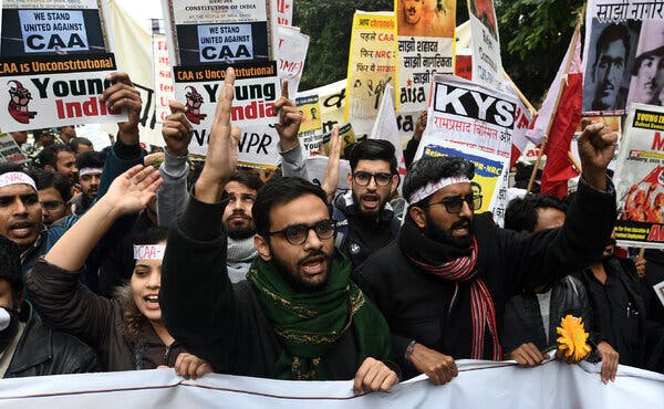 A crowd of men and women holding a white banner at a demonstration.